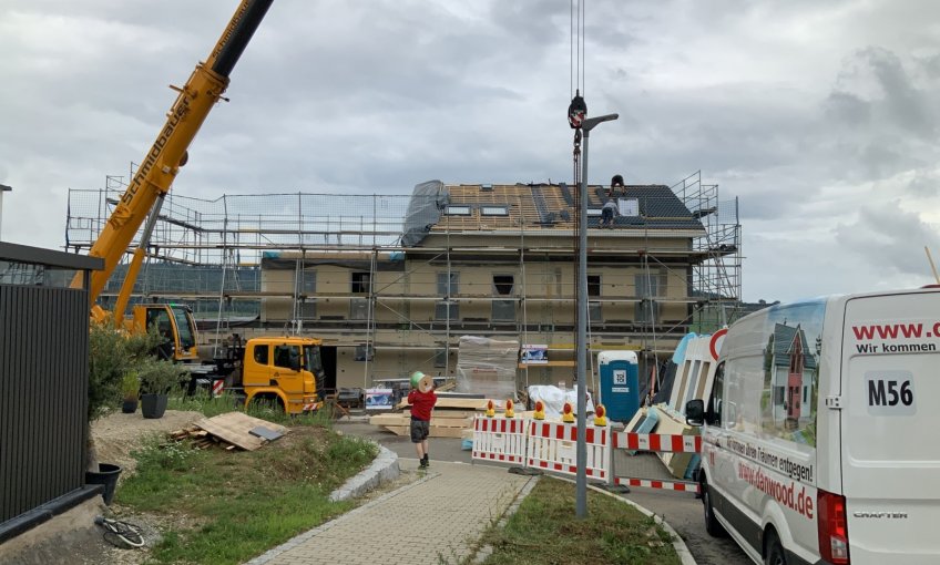 Mit der Dacheindeckung am ersten Haus sind die Arbeiten am äußerlichen Rohbau abgeschlossen.