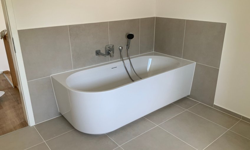 Die Fliesenarbeiten im Badezimmer wurden fertiggestellt und die Badewanne eingebaut.