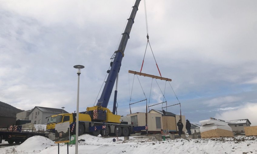 Mit Hilfe vom großen Kran wird das Haus abgeladen.